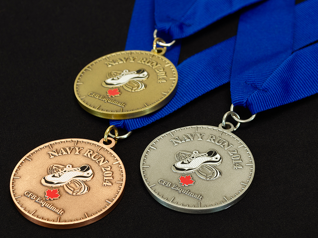 Custom sports medals in gold, silver, and bronze platings with blue ribbons.