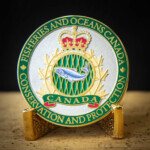 Polished gold and antique silver 2D coin with Imitation hard enamel paint (except for the soft enamel green behind the fish), and an offset printed fish Fisheries and Oceans Canada challenge Coin